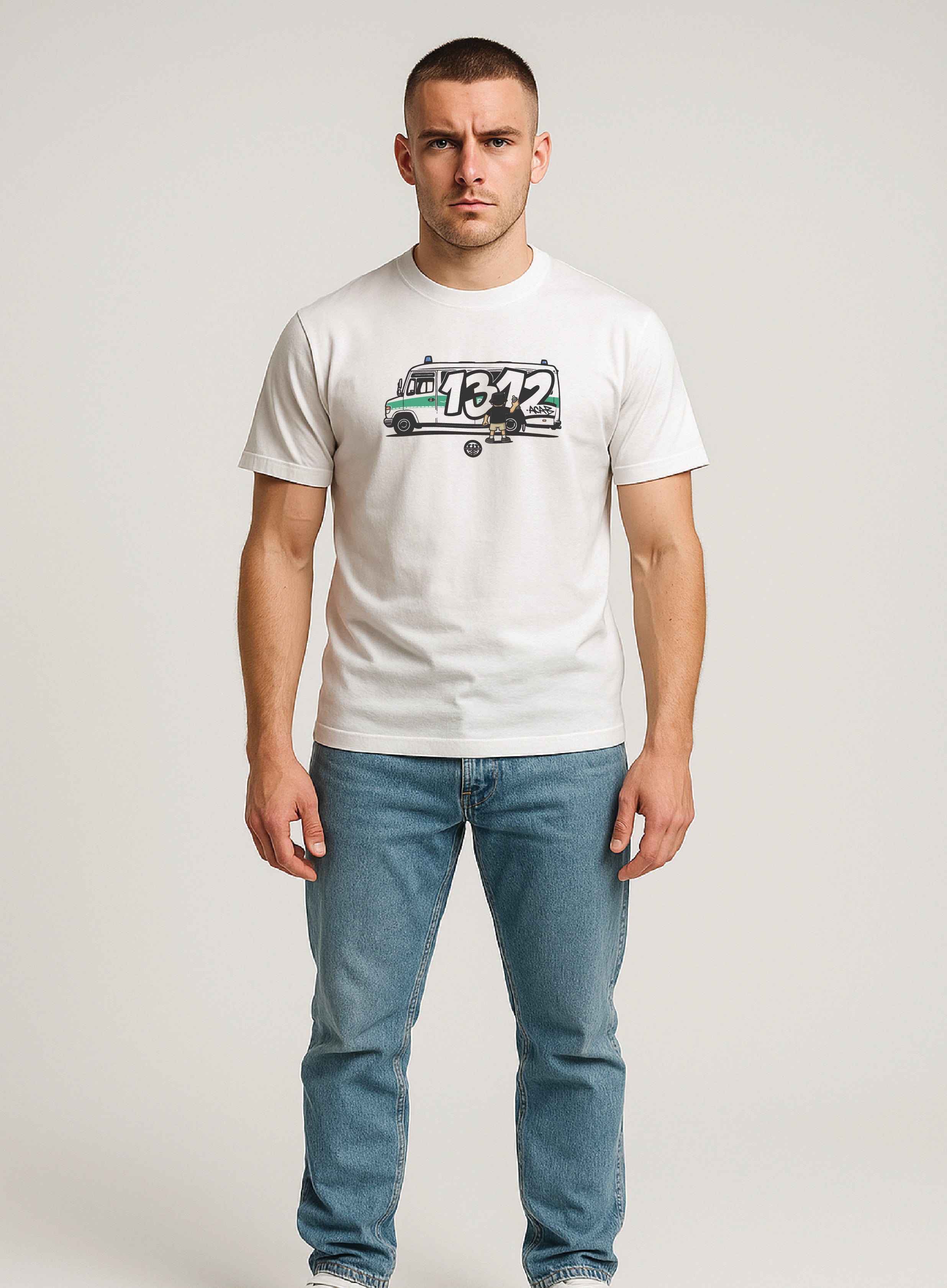 Man wearing a white 'ultras 1312' t-shirt with a logo and text, blue jeans, and white sneakers on a plain background