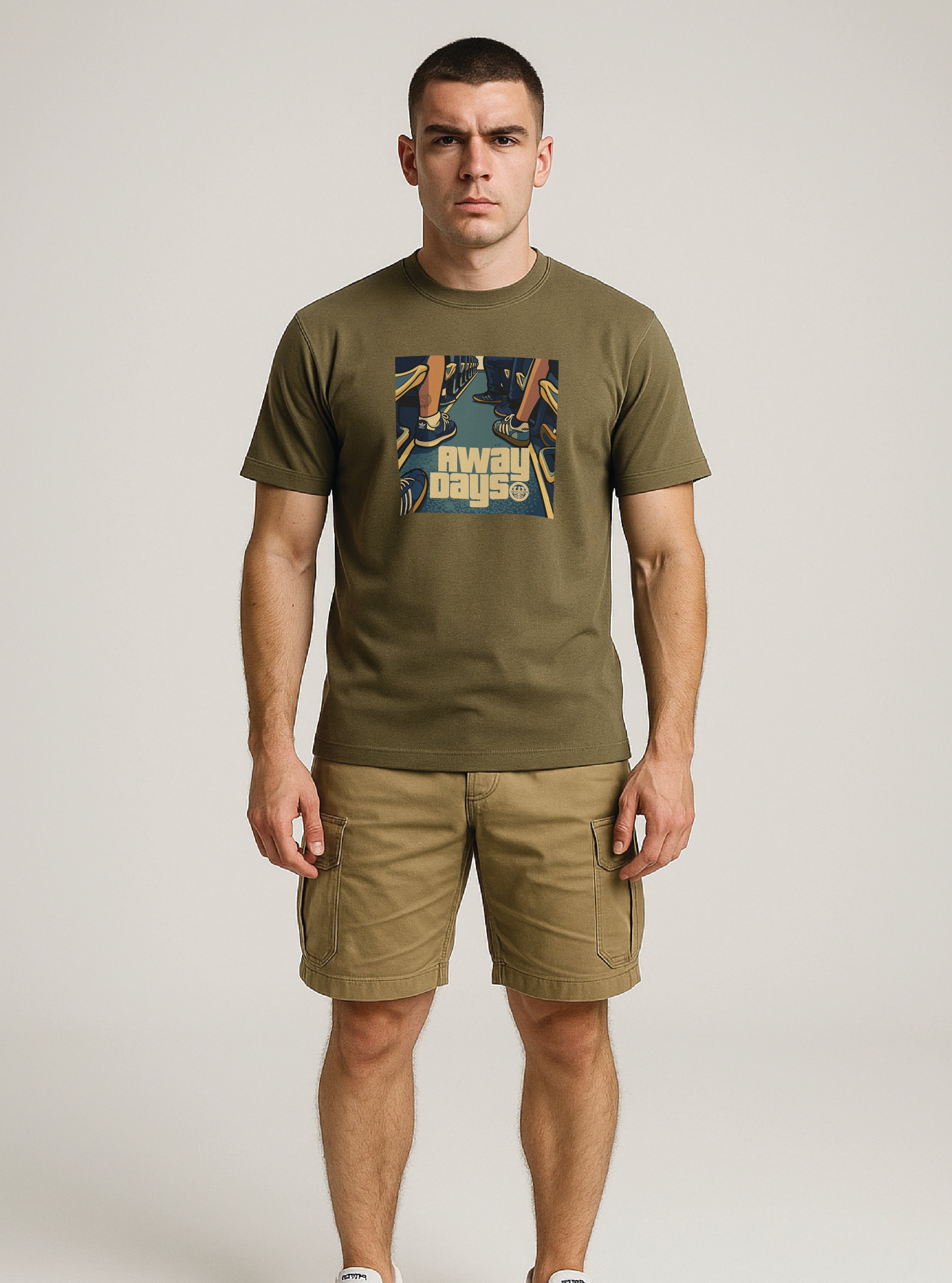 ultras Man wearing a khaki t-shirt with a AWAY DAYS graphic design and shorts on a white background