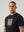 casuals ultras Man wearing a black England t-shirt with a graphic design on a plain background