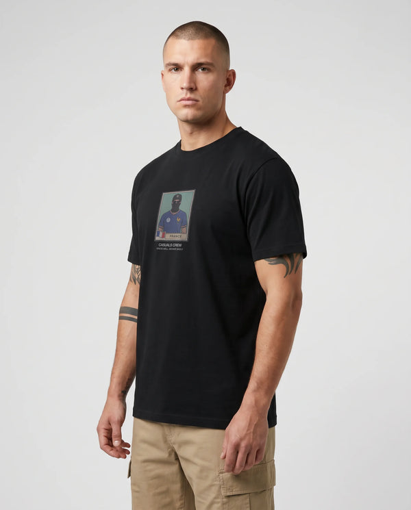 Man wearing a black t-shirt with a graphic design on a plain background