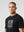casuals ultras Man wearing a black France World Cup t-shirt with a graphic design on a gray background