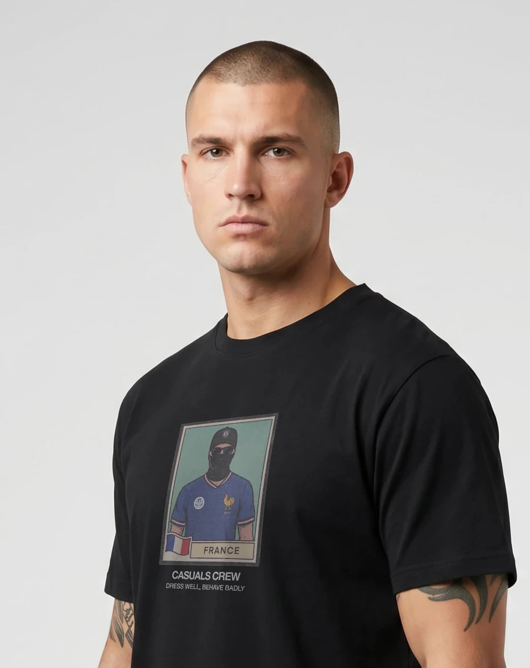 casuals ultras Man wearing a black France World Cup t-shirt with a graphic design on a gray background