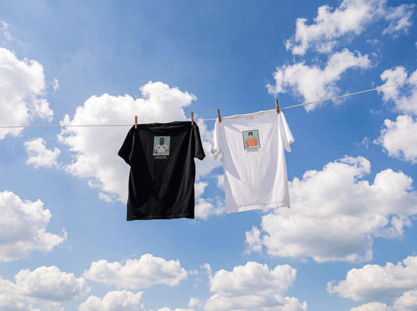 Black and whiteGERMANY AND HOLLAND WoRLD CUP t-shirts hanging on a clothesline against a blue sky with clouds.