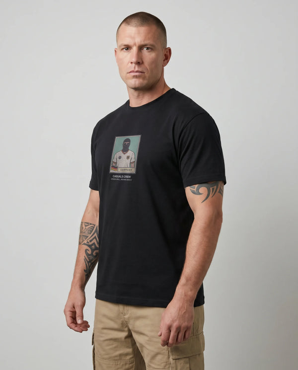 Man wearing a black t-shirt with a graphic design on a plain background