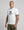 Man wearing a white t-shirt with a graphic design on a gray background