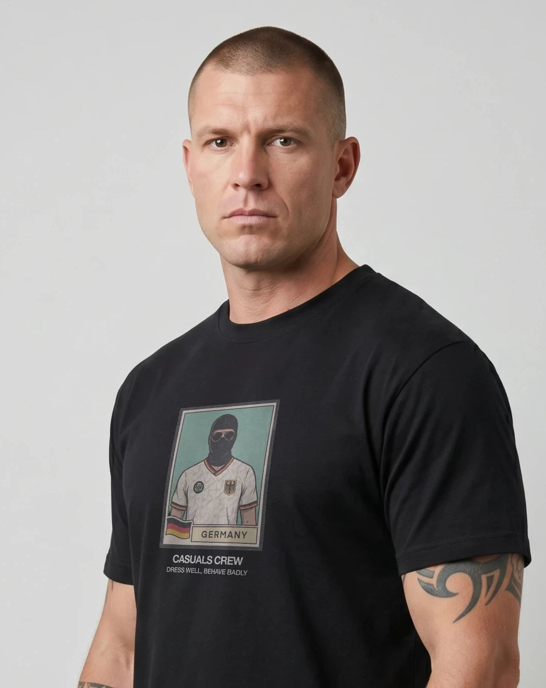 casuals ultras Man wearing a black Germany World Cup  t-shirt with a graphic design on a gray background