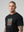casuals ultras Man wearing a black Holland World Cup  t-shirt with a graphic design on a gray background