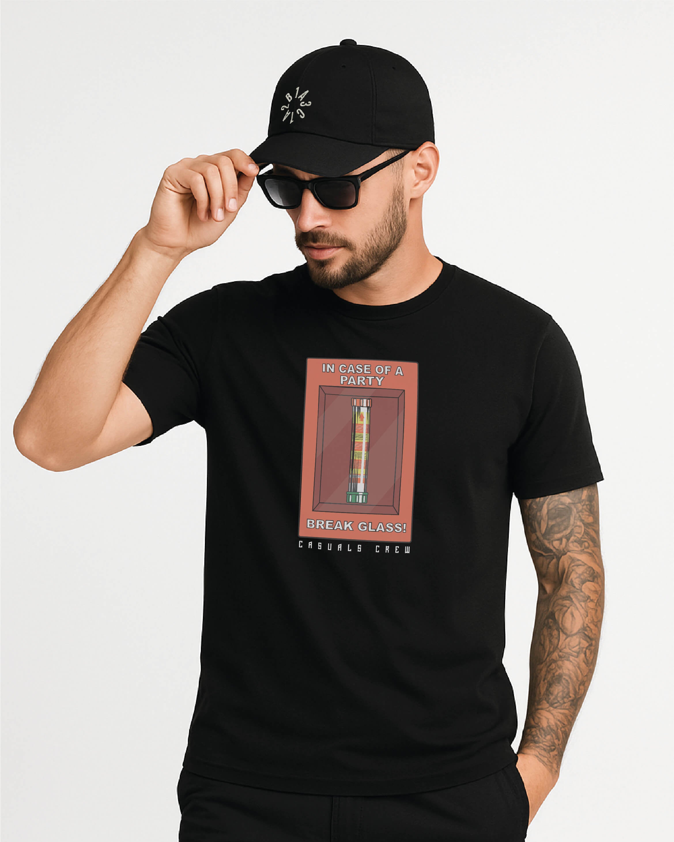 Man wearing a ultras black t-shirt with a no pyro no party design, holding a black 1312 cap, on a white background