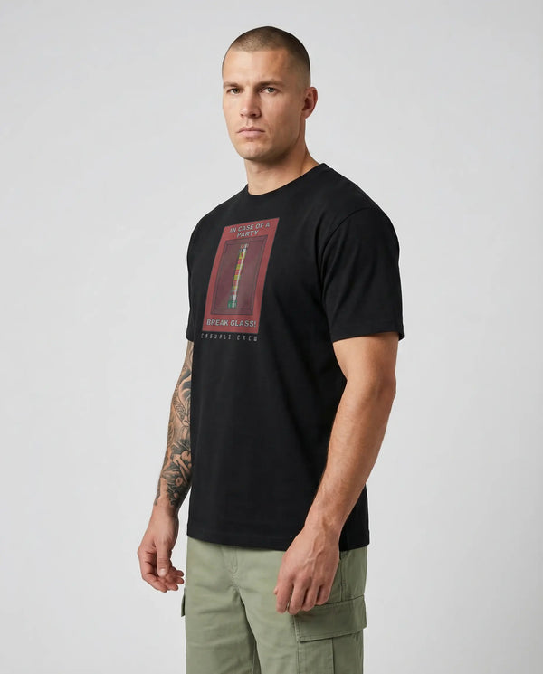 Man wearing a black t-shirt with a graphic design on a plain background