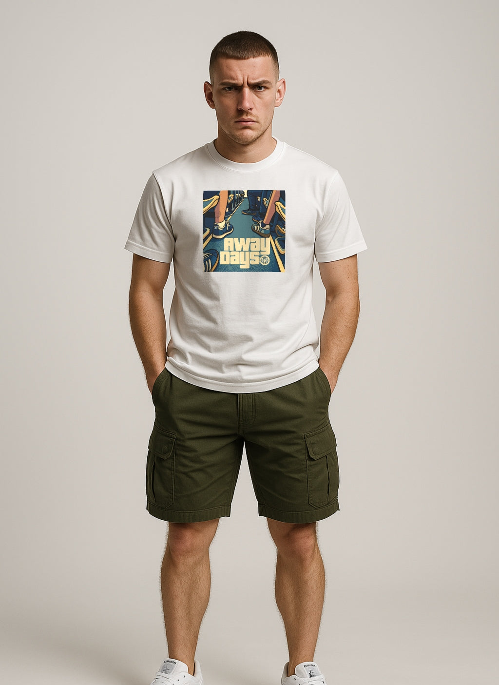 Man wearing a white ULTRAS t-shirt with a AWAY DAYS graphic design and green cargo shorts on a plain background